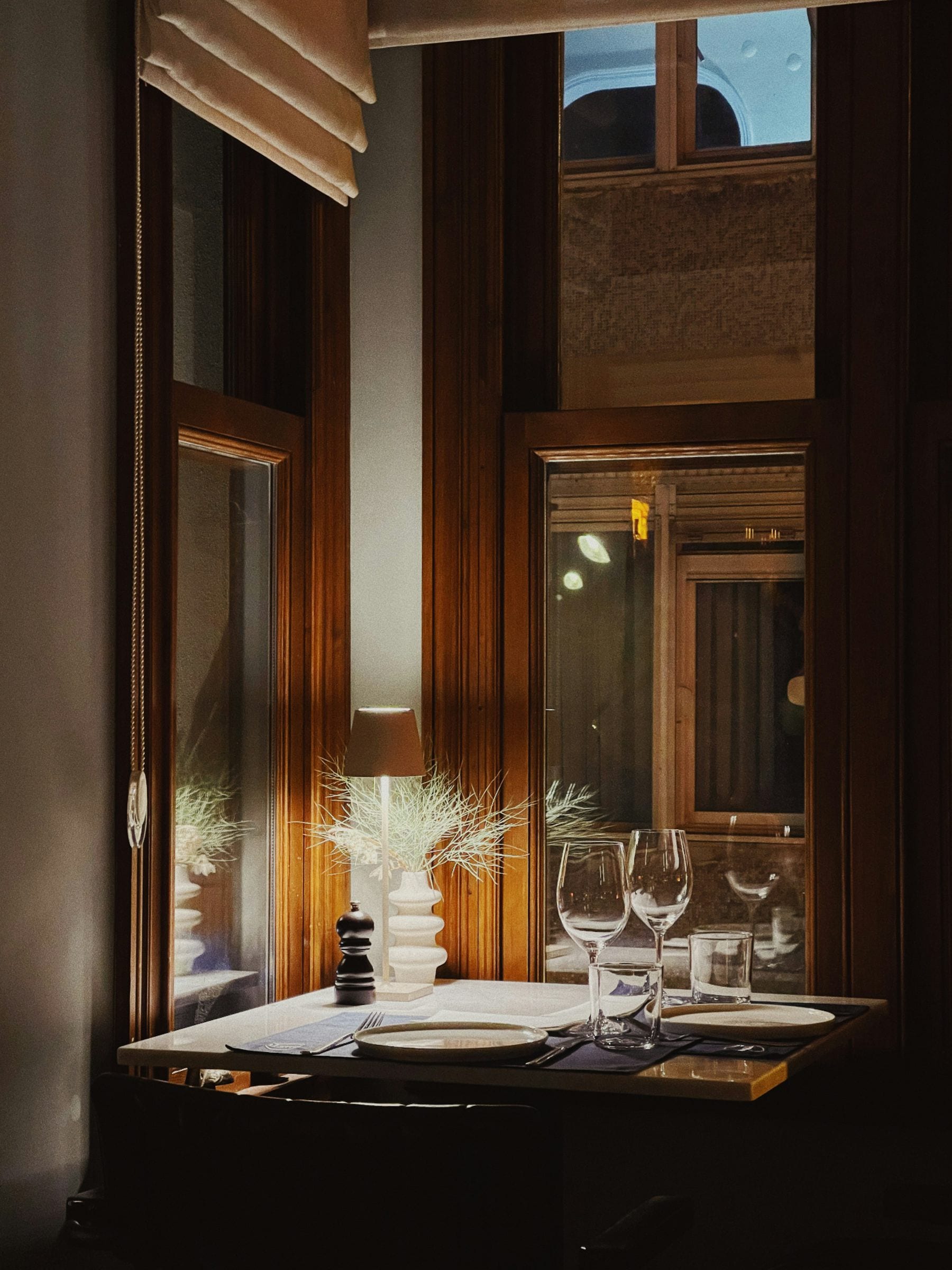 A maître d'hôtel finishes a dish on a terrace, the sea below.